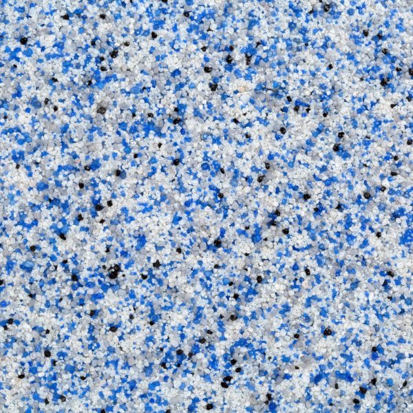 Textured surface of industrial-grade epoxy flooring granules in blue, white, and black — used for slip resistance and decorative finish in commercial or garage settings.