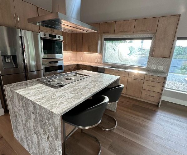 Modern kitchen with luxury finishes and wood-style floors installed by Red Eagle’s flooring installation services