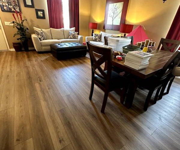 Warm and inviting living and dining area featuring new vinyl plank flooring — request your Free Flooring Quote from Red Eagle Flooring.