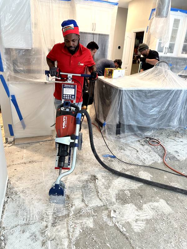 Old flooring being removed down to the subfloor during a tear-out