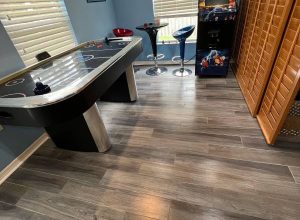 Modern vinyl plank flooring installed in a stylish game room — Free Flooring Quote available for residential projects like this one.