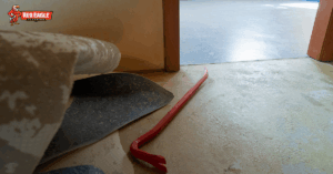 Close-up of old flooring being removed with a crowbar during a flooring renovation project