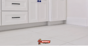 Clean white ceramic tile Florida flooring in a bright bathroom with elegant white cabinetry, demonstrating quality installation by Red Eagle Flooring.