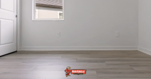 Modern gray laminate Florida flooring installed in a neutral room with white walls, highlighting a clean and contemporary residential update by Red Eagle Flooring.