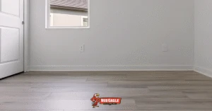 Modern gray laminate Florida flooring installed in a neutral room with white walls, highlighting a clean and contemporary residential update by Red Eagle Flooring.