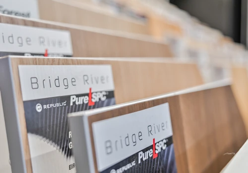 Focused shot of Republic Bridge River Pure SPC flooring swatches, showcasing realistic wood grain patterns and brand labeling to assist homeowners in choosing the perfect style.