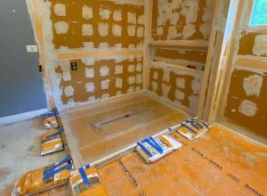 Shower area under construction with waterproofing membrane and tools — part of tile flooring installation services