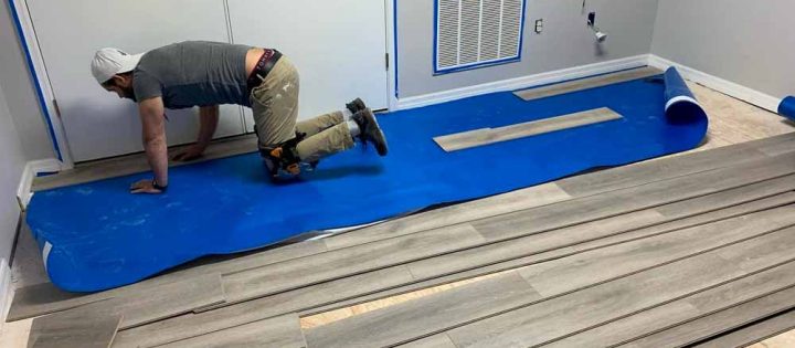 A skilled floor installer working on the interior flooring of a home improvement project