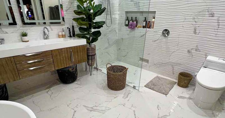 An improved bathroom with tile flooring installed and a textured shower tile backsplash